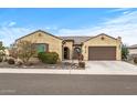 Tan stucco house with a tile roof, two-car garage, and drought-tolerant landscaping at 18852 N 260Th Ln, Buckeye, AZ 85396