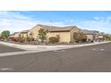 Corner lot home with tan stucco, tile roof, and mature desert landscaping at 18852 N 260Th Ln, Buckeye, AZ 85396