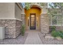 Elegant entryway with a stone facade and wrought-iron door at 2330 E Brooks Farm Rd, Gilbert, AZ 85298