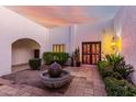 Charming courtyard with a fountain, colorful door, and lush landscaping at 2221 E Northview Ave, Phoenix, AZ 85020