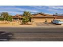 House exterior featuring a two-car garage and mature palm trees at 13106 W Lyric Dr, Sun City West, AZ 85375