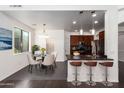 Modern kitchen with breakfast bar, dark wood cabinets, and stainless steel appliances at 10350 W Foothill Dr, Peoria, AZ 85383