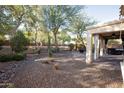 Landscaped backyard with covered patio, fire pit, and spa at 26053 W Tonopah Dr, Buckeye, AZ 85396