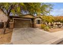 One-story home with brown brick exterior, two-car garage, and desert landscaping at 298 E Diamond Trl, San Tan Valley, AZ 85143
