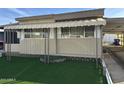 Front view of tan mobile home with awning and landscaping at 5201 W Camelback W Rd # D69, Phoenix, AZ 85031