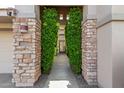 Stone pillars and lush greenery frame the entry to this beautiful home at 10975 E Greenway Rd, Scottsdale, AZ 85255