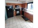 Galley kitchen with wood cabinets and black appliances at 1217 E Fremont Dr, Tempe, AZ 85282