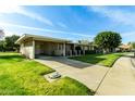 Ranch home with carport, driveway and lawn at 10801 W Clair Dr, Sun City, AZ 85351