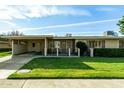 Brick ranch home with carport and landscaped lawn at 10801 W Clair Dr, Sun City, AZ 85351