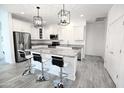 Modern kitchen with white cabinets, granite counters, and stainless steel appliances at 18157 W Foothill Dr, Surprise, AZ 85387