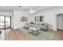 Bright living room with light gray sectional sofa and wood-look floors at 3244 E Hononegh Dr, Phoenix, AZ 85050