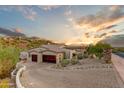 Two-car garage with a large driveway and mountain views in the background at 9749 N Fireridge Trl, Fountain Hills, AZ 85268