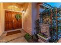 Elegant entryway with double doors, a fountain, and lush landscaping at 14414 N 57Th Way, Scottsdale, AZ 85254