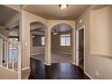 Bright and spacious entryway with dark hardwood floors and arched doorways at 2542 N Riley Rd, Buckeye, AZ 85396