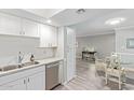 White kitchen cabinets, granite counters, and view into dining area at 4200 N Miller Rd # 309, Scottsdale, AZ 85251
