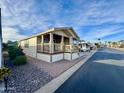Tan single-wide manufactured home with covered porch and carport at 9333 E University Dr # 51, Mesa, AZ 85207