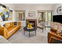 Living room with a fireplace, leather sofas, and sliding glass doors leading to a patio at 15050 N Thompson Peak Pkwy # 2053, Scottsdale, AZ 85260