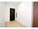 Modern condo entryway with dark wood door and light tile floors at 7120 E Kierland Blvd # 520, Scottsdale, AZ 85254