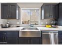 Kitchen features a farmhouse sink and stainless steel dishwasher at 14850 W Laurel Ln, Surprise, AZ 85379