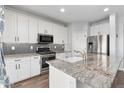 Modern kitchen with white cabinets, granite counters, and stainless steel appliances at 9814 E Palladium Dr, Mesa, AZ 85212