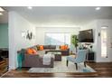 Bright living room featuring L-shaped sectional sofa and large TV at 10601 N 26Th Pl, Phoenix, AZ 85028