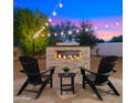 Relaxing outdoor space with a brick fire pit, comfortable seating, and string lights at 17870 E Appaloosa Dr, Queen Creek, AZ 85142