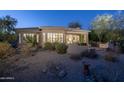 Back exterior view of house with desert landscaping and patio at 11233 E Butherus Dr, Scottsdale, AZ 85255