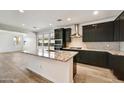 Modern kitchen with dark cabinetry, granite countertops, and stainless steel appliances at 17313 W Wandering Creek Rd, Goodyear, AZ 85338