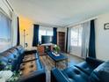 Living room with dark leather couches and wood-look floors at 305 S Val Vista Dr # 204, Mesa, AZ 85204