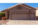 Two-car garage and front entry of tan house at 11553 W Sonoran Ct, Surprise, AZ 85378