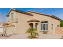 Two-story house with a tan exterior, two-car garage, and palm trees at 15867 N 164Th Ln, Surprise, AZ 85388