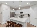 Modern kitchen with white cabinets, island with seating, and stainless steel appliances at 1723 S 83Rd Way, Mesa, AZ 85209