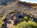 Luxury estate home nestled on a hillside lot with desert landscaping at 10030 N 23Rd St, Phoenix, AZ 85028