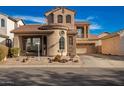 Two-story house with tan exterior, stone accents, and a two-car garage at 1306 S Normandy --, Mesa, AZ 85209