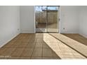Empty spare bedroom with tile flooring and sliding glass door to backyard at 3007 W Redfield Rd, Phoenix, AZ 85053