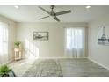 Living room featuring light walls, wood-look floors, and a large window at 8651 N 56Th Dr, Glendale, AZ 85302