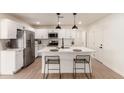 Bright kitchen featuring white cabinets, island with seating, and stainless steel appliances at 813 E Garnet Ave, Mesa, AZ 85204