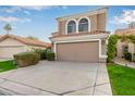 Two-story house with tan exterior, arched windows, and a two-car garage at 1321 W Clear Spring Dr, Gilbert, AZ 85233