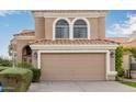 Tan two-story house featuring arched windows and a two-car garage at 1321 W Clear Spring Dr, Gilbert, AZ 85233