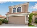 Two-story house with tan exterior, arched windows, and a two-car garage at 1321 W Clear Spring Dr, Gilbert, AZ 85233