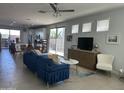 Open concept living area with a blue sofa, a large TV, and a view to the kitchen at 4856 S Tune --, Mesa, AZ 85212