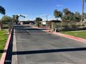 Gated community entrance with paved road and landscaping at 4901 S Calle Los Cerros Dr # 202, Tempe, AZ 85282