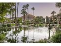 Serene pond with a fountain, lush landscaping, and arched stone features at 6161 N 59Th Pl, Paradise Valley, AZ 85253