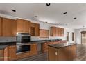 Well-equipped kitchen with dark countertops and wooden cabinets at 19668 E Carriage Way, Queen Creek, AZ 85142