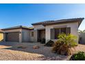 Single-story home with a two-car garage and desert landscaping at 21171 E Stirrup St, Queen Creek, AZ 85142