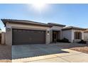 Single-story home with a two-car garage and desert landscaping at 21171 E Stirrup St, Queen Creek, AZ 85142