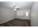 Bright living room featuring dark laminate floors and ceiling fan at 523 N Criss St, Chandler, AZ 85226