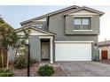 Two-story house with gray siding, white garage door, and landscaped front yard at 11311 E Upton Ave, Mesa, AZ 85212