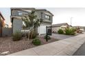 Two-story house with gray siding, white garage door, and landscaped front yard at 11311 E Upton Ave, Mesa, AZ 85212