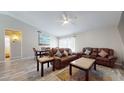 Living room with hardwood floors, a brown leather sectional sofa and a dining area at 15420 N 160Th Ln, Surprise, AZ 85374